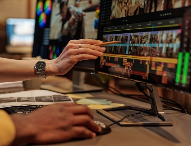 Close-up of two designers using editing software on computer to montage photo and video